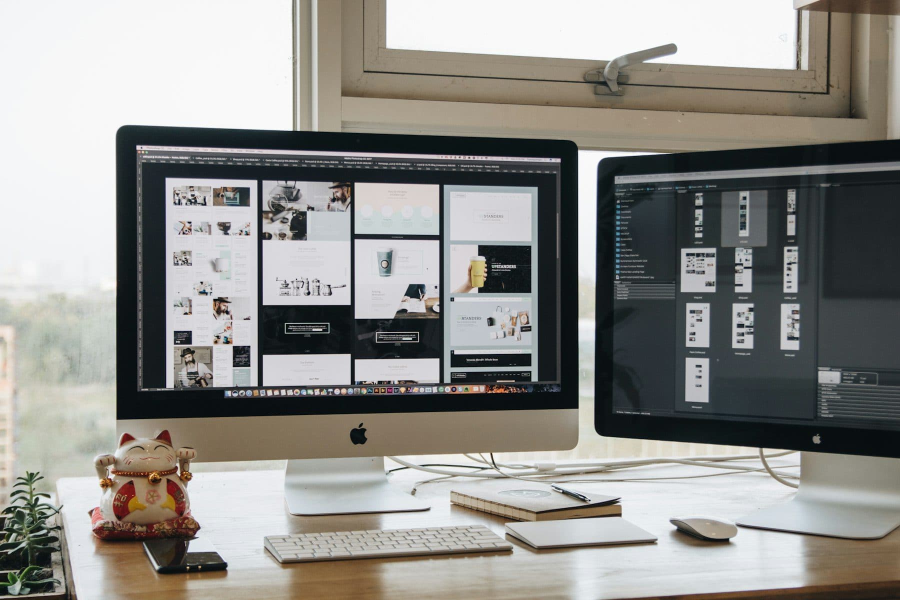 Two monitors on a designer's desk showing layouts