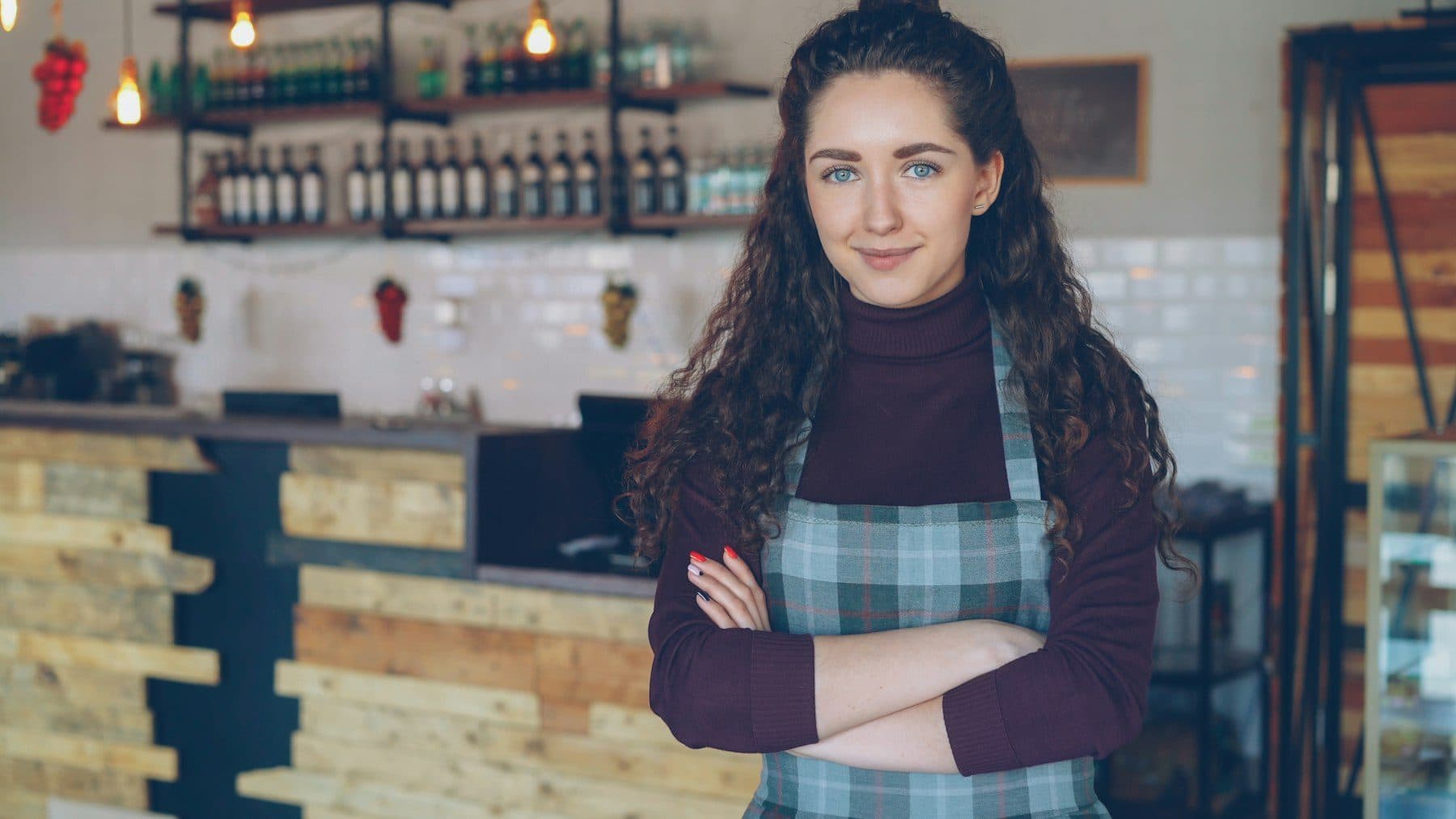 Smiling café owner in front of her counter