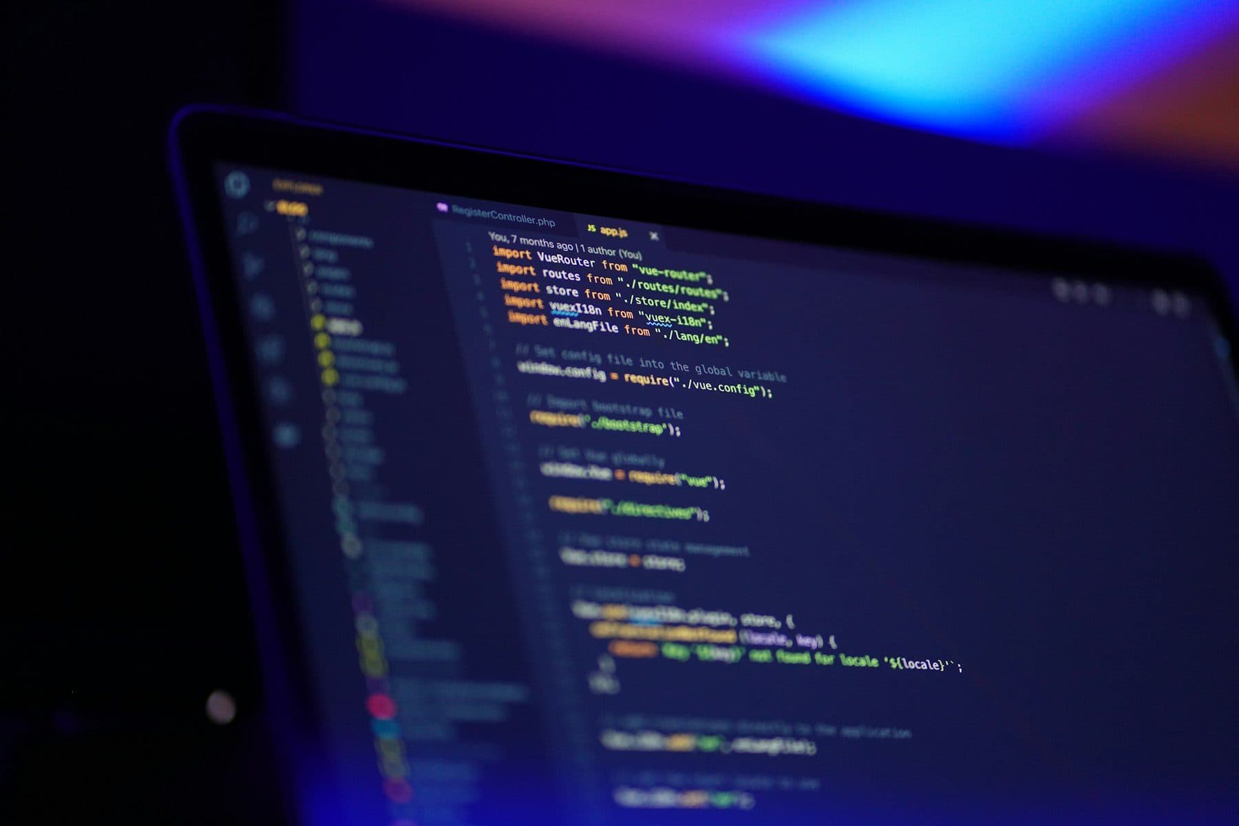 Laptop screen with colourful code in a dark room